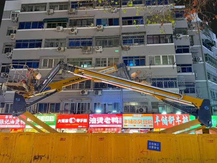 穿街过巷的“改造艺术家”！开云网页版登录入口电动直臂高空作业平台精准施技丰储街改造